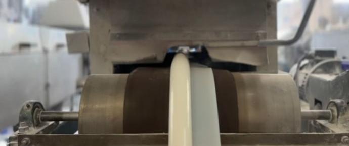 A white rubber seal being manufactured on a rubber extruder A white rubber seal being manufactured on a rubber extruder