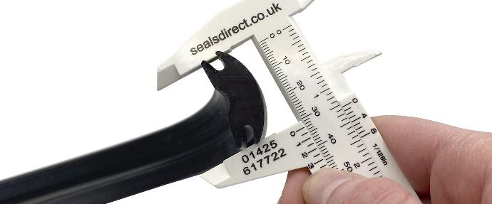 A plastic venier measuring the width of a rubber seal